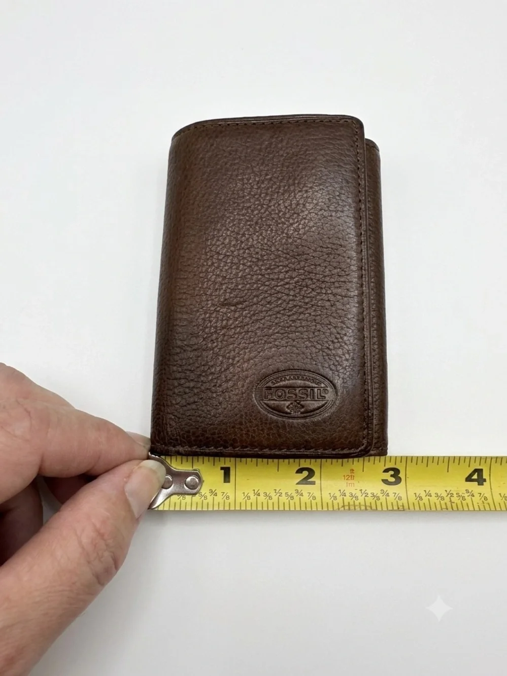leather Fossil tri-fold key holder wallet featuring six metal key hooks.
